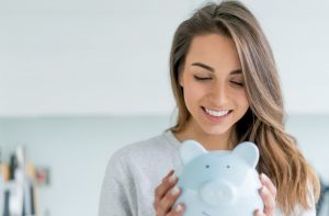 A woman is happily looking toward her money box. Financial independence creates happiness for a woman.
